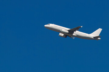 A white airplane against a blue sky