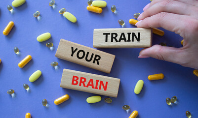 Train Your Brain symbol. Concept words Train Your Brain on wooden blocks. Beautiful purple...