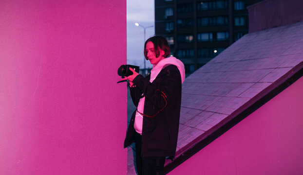 Non binary person with camcorder on the street