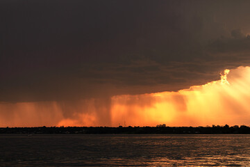 Sunset over the lake with rain in the background