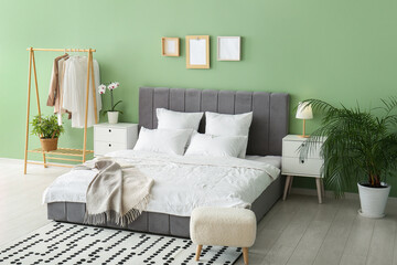 Comfortable bed, pillows and bedside tables in stylish bedroom