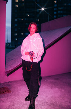 Non binary person with camcorder on the street