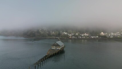 Drone shot of Garibaldi Historic US Coast Guard Boathouse on a foggy day in Garibaldi, Oregon, USA