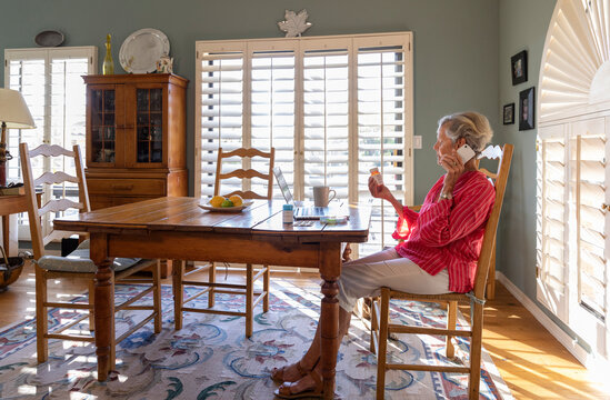 Woman holds prescription pill bottle  Talking on cell phone 