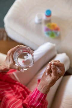 Senior woman holding single prescription pill medication in hand 