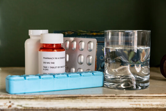 Prescription pills on table with glass of water   