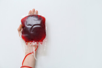 Female hand with blood pack on white background. World Blood Donor Day