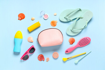 Beautiful composition with cosmetic bag, sunscreen and accessories on blue background