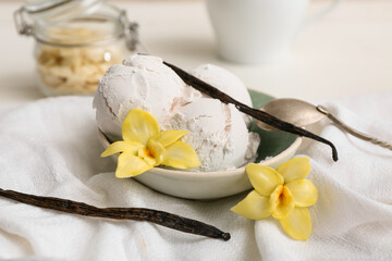 Bowl of sweet vanilla ice-cream balls with sticks and flowers on white background