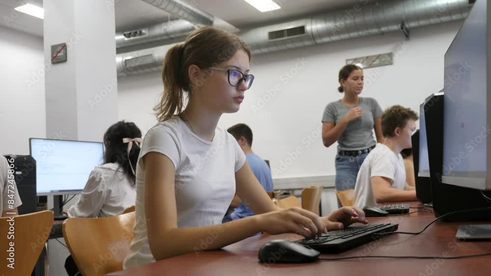 Poster focused female student in glasses using pc and studying computer science in the classroom