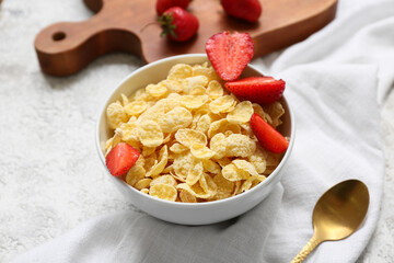 Wooden cutting board, napkin and bowl with cornflakes on grunge background, closeup