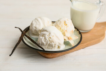 Wooden cutting board and plate with tasty vanilla ice cream on table, closeup