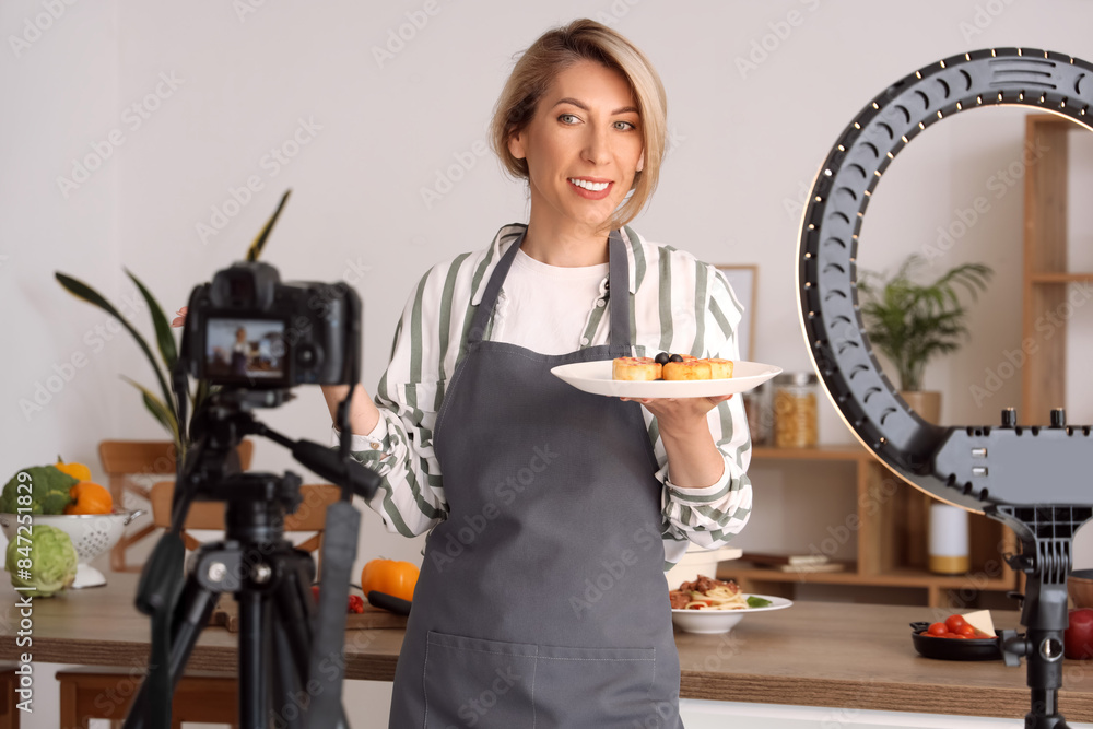 Sticker female food blogger with tasty cheese cakes recording video in kitchen