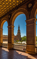 Fototapeta premium Looking through the archways to the Towers of the beautiful Plaza de Espana (translates to Spanish Square) in Seville, Spain.