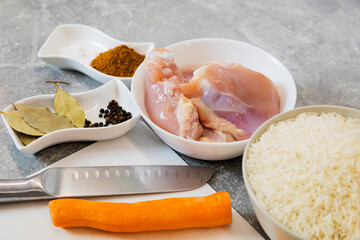 The chef prepares homemade crispy fried chicken with carrots and onions, spices.