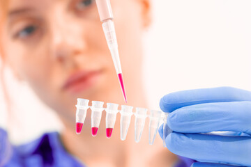 young woman in genetics laboratory working with pipette and micro tubes