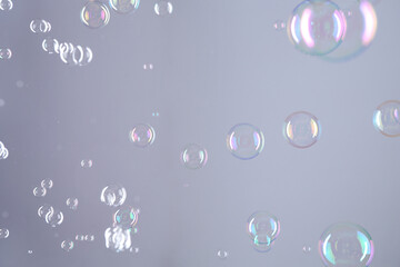 Beautiful transparent soap bubbles on grey background