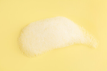 Sample of fluffy foam on yellow background, top view