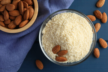 Fresh almond flour and nuts on blue wooden table, flat lay