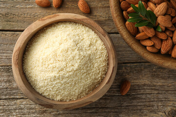 Fresh almond flour, branch and nuts on wooden table, flat lay