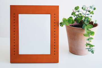 白背景のフォトフレーム(写真立て)と観葉植物　モックアップ