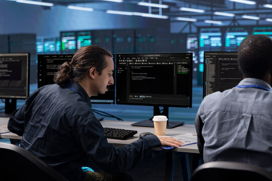 Coworkers in data center workspace running system diagnostic tests to do repairments. IT experts at PC desk in server hub deploying error checking utilities to fix network issues - Powered by Adobe