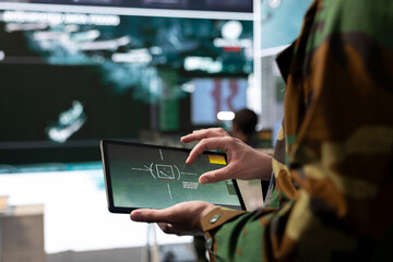 Military IT engineer collecting intelligence from world map projection, tablet connected to radar...