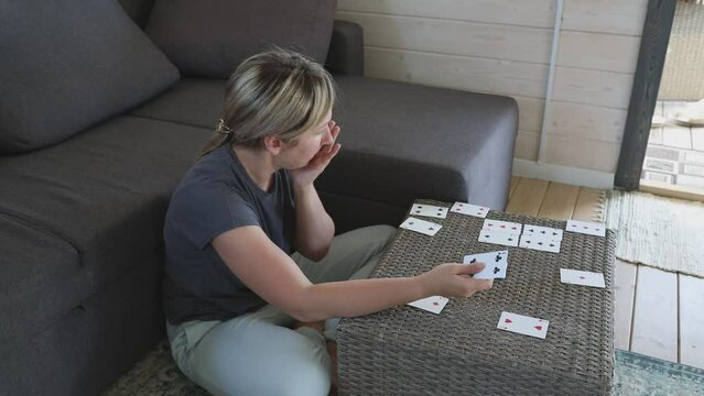Woman Plays Card Game on Coffee Table