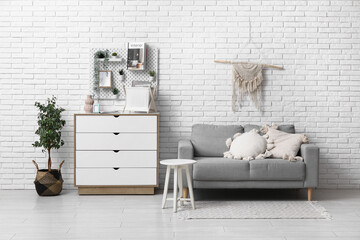 Living room with grey sofa, coffee table, chest of drawers and pegboard
