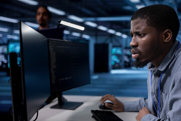 Admin frowning after seeing error in server farm while overseeing supercomputers used for managing...
