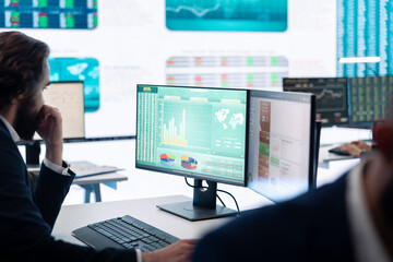 Chief financial officer studying capital funds and revenue data on his computer, verifying annual...