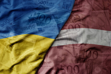 big waving realistic national colorful flag of latvia and national flag of ukraine on a euro money banknotes background.