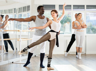 Obraz premium Adult man and adult woman perform paired ballet dance in studio