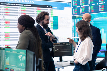 Staff members from a business enterprise discussing details and progress in a new project during a...