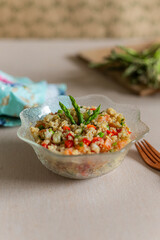 Fresh summer quinoa salad on glass bowl with wooden fork