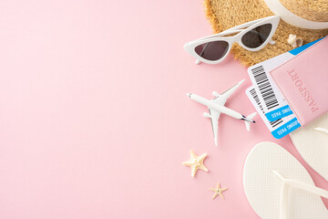 Flat lay of summer travel essentials featuring passport, boarding passes, sunglasses, and beach hat...
