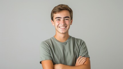A young man with a warm and friendly expression, standing with his arms crossed