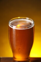 Glass with fresh beer on table against dark background, closeup