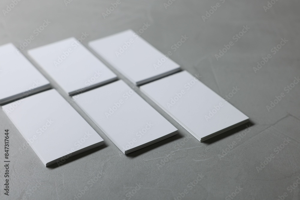 Wall mural Blank business cards on light grey textured table, closeup. Mockup for design - Wall murals