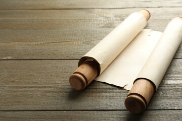 Sheet of old parchment paper with handles on wooden table, space for text