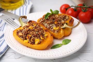 Quinoa stuffed peppers with corn and basil on white textured table