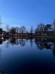 Fototapeta premium Scenic view of river and buildings on shore in evening