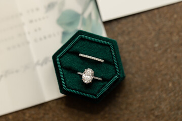 Diamond engagement ring and wedding band in green velvet box.

