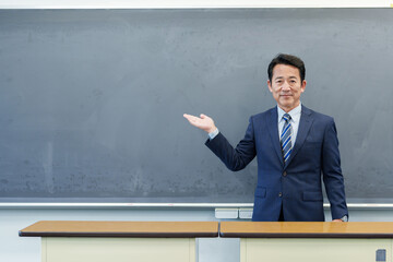 黒板を指し示す教師