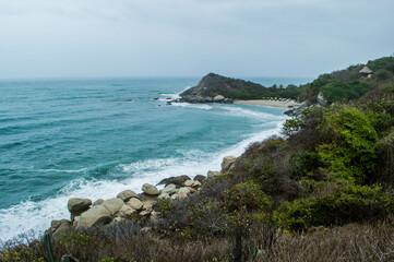 Paisaje azul cielo, playa, rocas y selva 