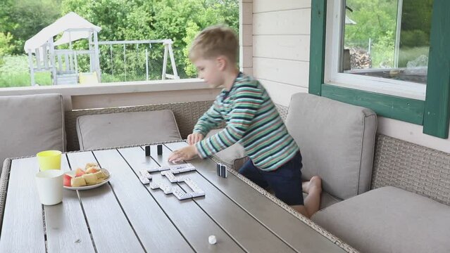 Family Dominoes Game on Terrace on Summer Day