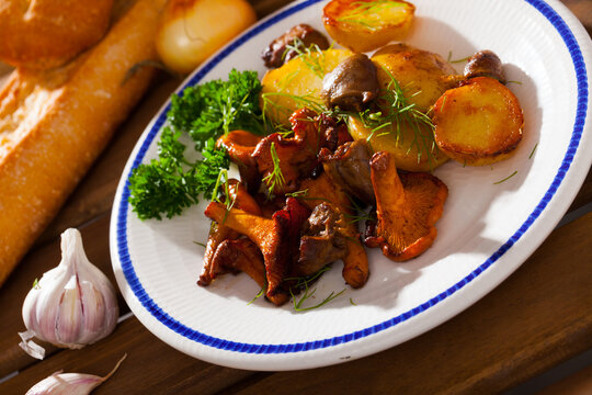 Delicious fried girolles with baked potatoes and chicken hearts garnished with fresh greens