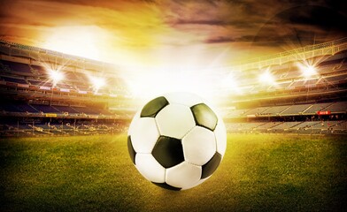 Classic soccer ball on green field in stadium