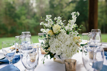 Elegant table setting with white floral centerpiece and wine glasses.

