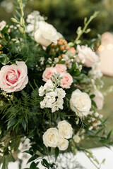 Close-up of a floral arrangement with pink and white roses and greenery